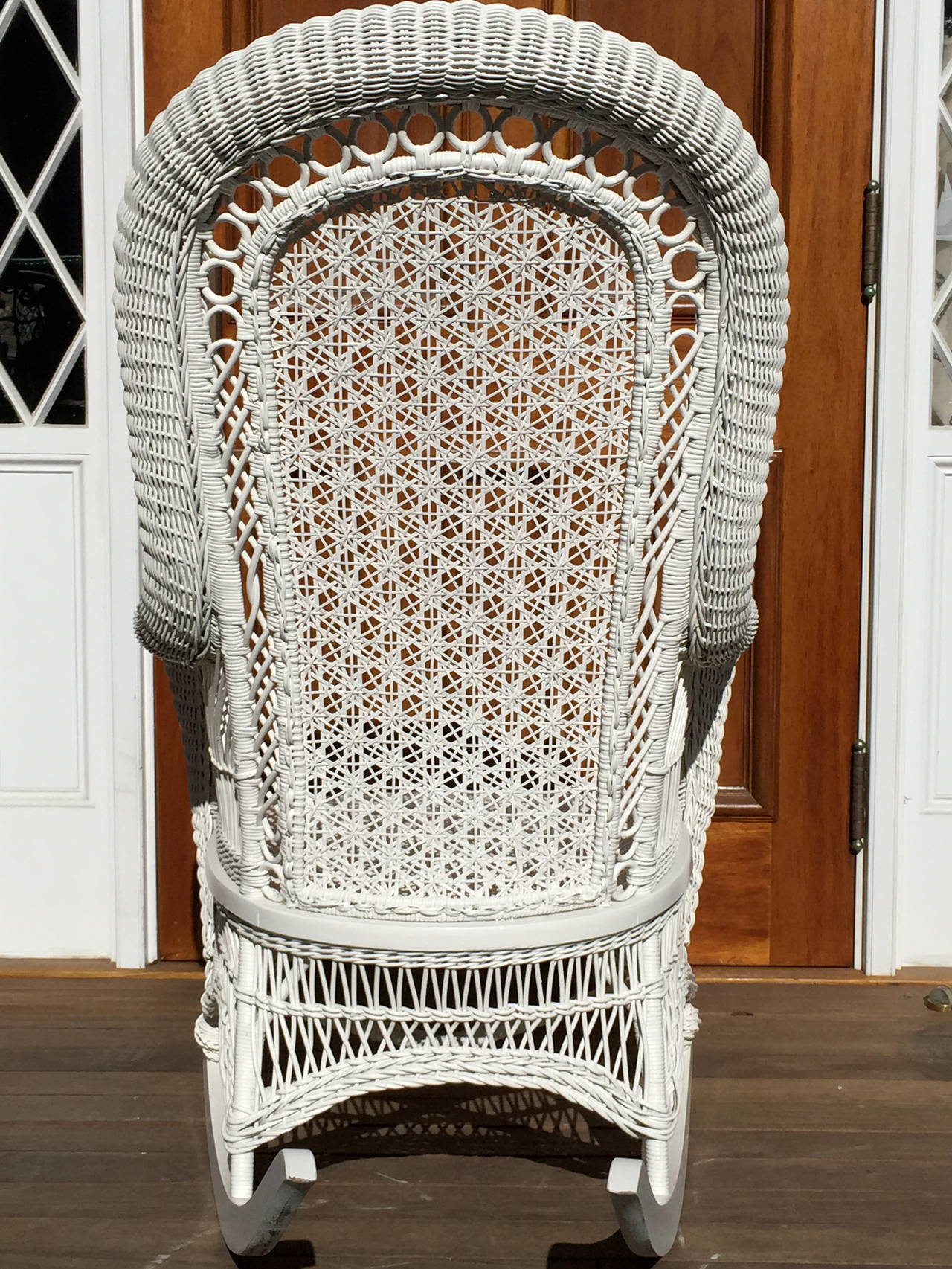 Beautiful and large scale antique wicker rocker.  rocker measures 42"tall, 26"wide, 36"deep.