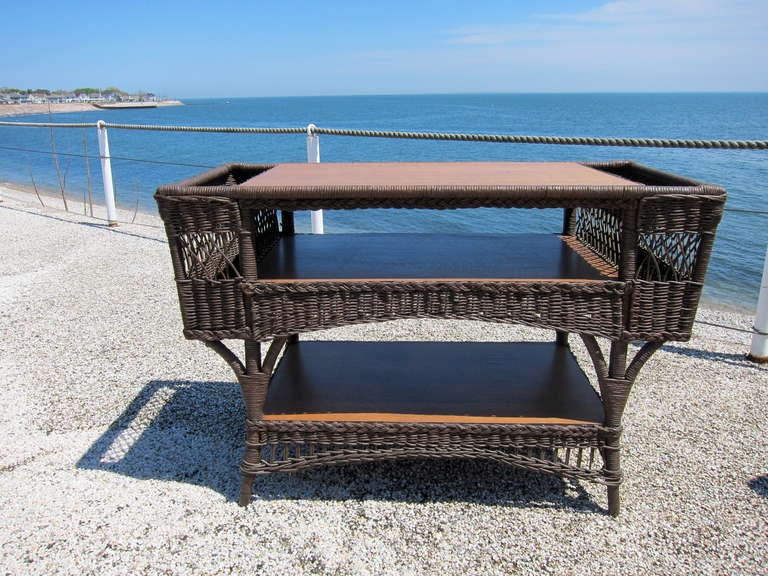 Beautiful fiber wicker table with oak shelves and side magazine pockets.  Matches three piece set featured in item # 1127.