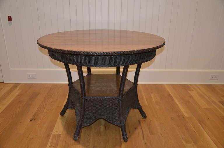 Six legged antique wicker table with quarter sawn oak top and lower shelf.  Matches set shown in separate listing.