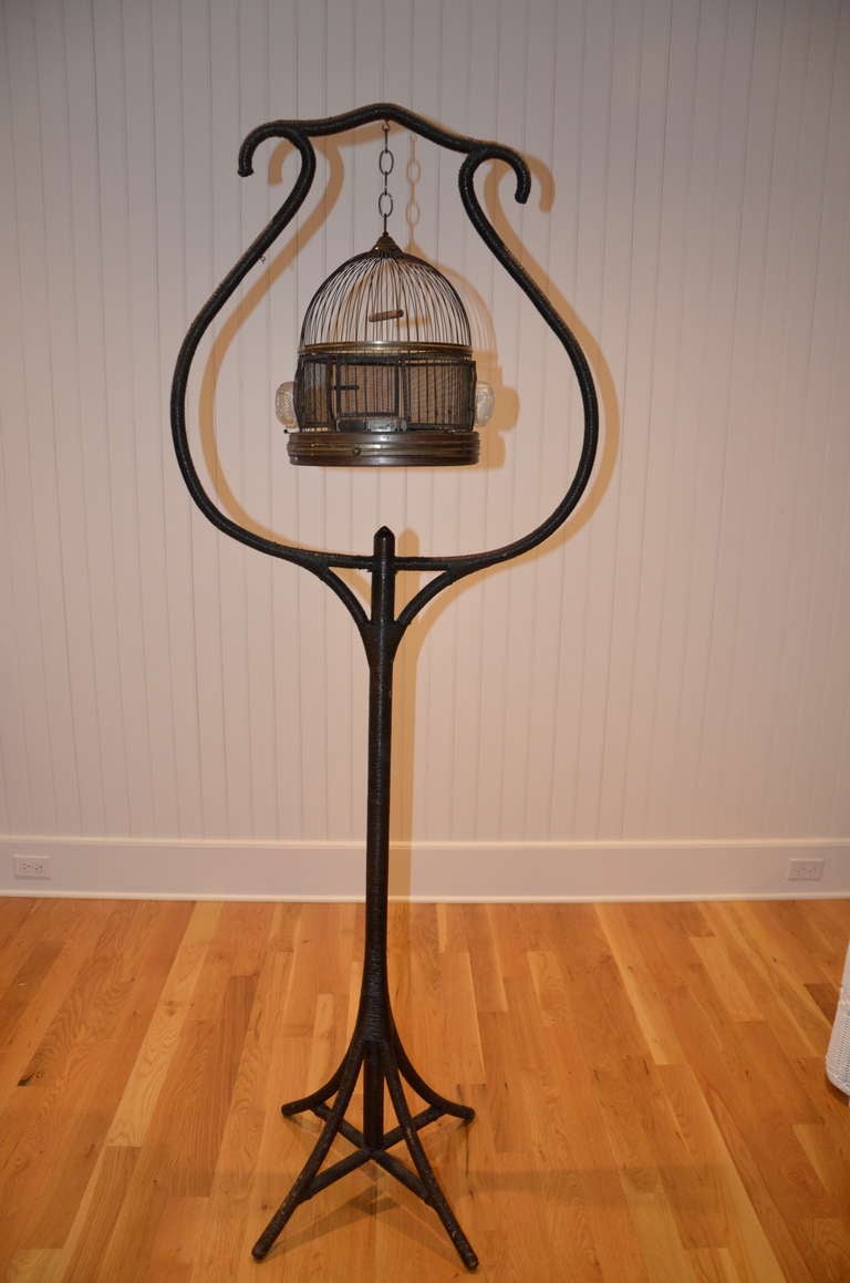 Merikord Antique Wicker Birdcage and Stand in original finish.  Birdcage has detachable bottom and removable tin tray.

Height 78