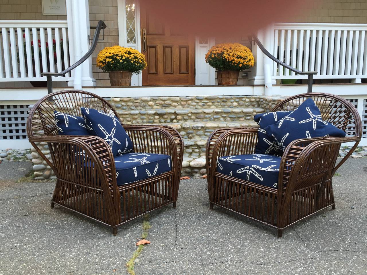 A pair of antique stick wicker/Rattan lounge chairs in natural finish. These chairs are generously sized and extremely comfortable. Cushions shown are not included but are for display purposes only.
