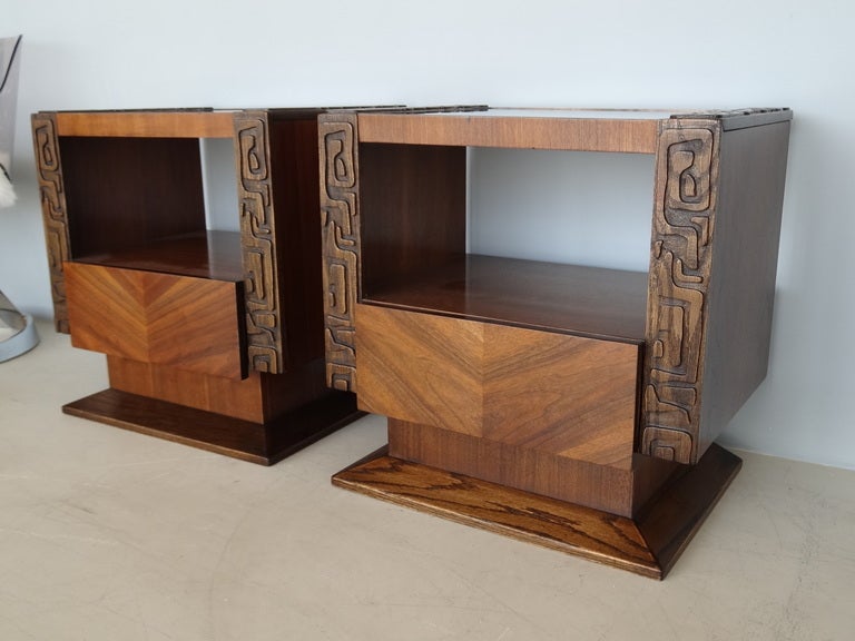 A pair of wonderful sidetables on pedestal bases. Wide abstract decoration. Inset glass tops and one drawer each.
