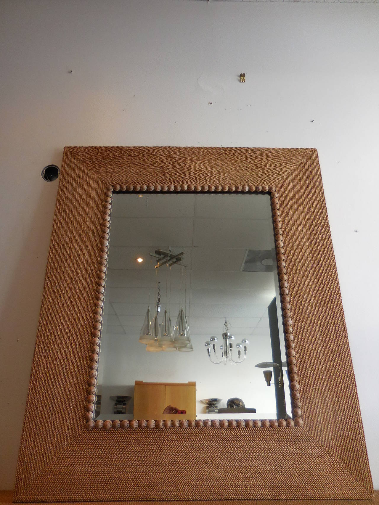 This is a large mirror, the frame is done in seaweed rope and accented with shells around the inset beveled mirror.
