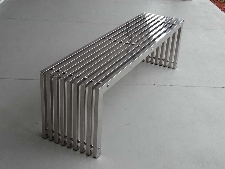 A stunning polished stainless steel bench. Classic design in the most unexpected material. Seamless construction in heavy gage stainless steel. A rare gem that can be used in ay room.