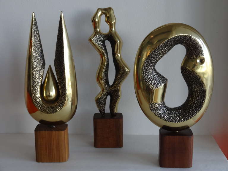 3 piece collection of mid century brass sculptures. Nice shapes with polished and textural surfaces. One signed as pictures. Teak bases. Tallest is 17.5
