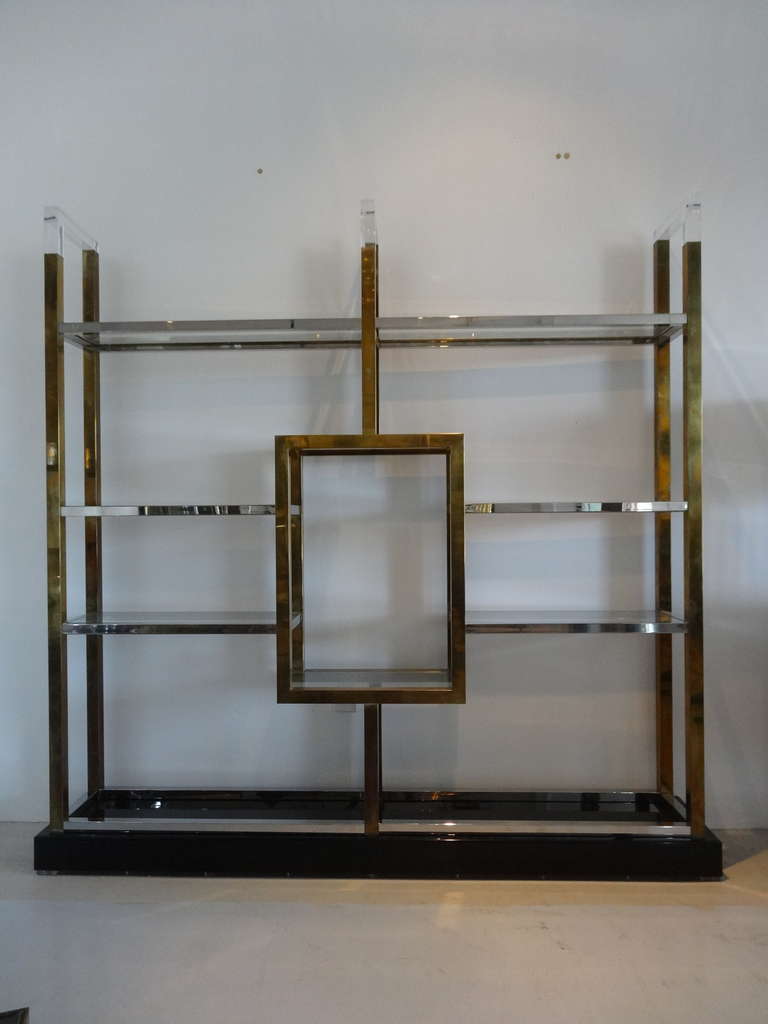 Stunning wall unit by Romeo Rega. Brass and chrome shelves on a black lucite base. Note the clear Lucite accent on top.