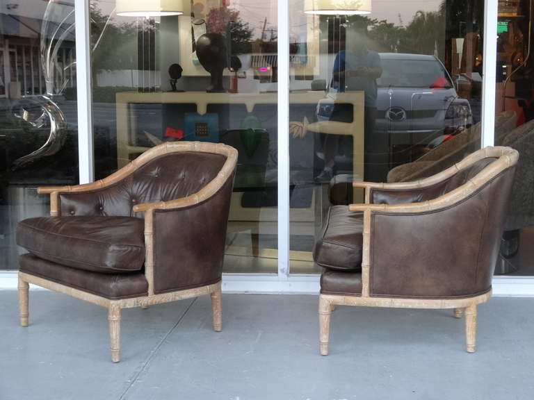 A pair of lounge chairs by Henredon. Exquisite faux bambbo frames with the original leather upholstery. Super comfortable as well as great looking from any angle.
