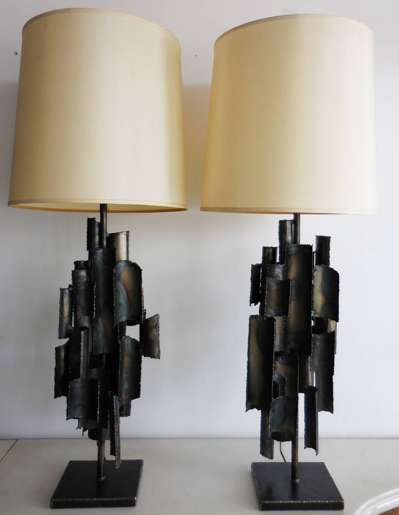A monumental pair of sculptural lamps. Conceived as a pair each lamp is a unique artistic creation with it's own design and individual nuances. Spectacular from any angle. Both signed on bottom. Shades diameter is 18