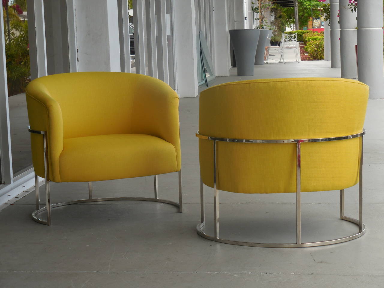 A pair of beautiful chairs by Milo Baughman. Round metal bases with floating tub seats. Simple design with wonderful proportions. Super comfortable.