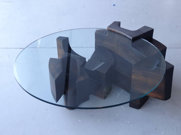Stunning carved wood and glass coffee table. Done in the futurist style with multiple shapes in a dynamic arrangement. Note the subtle metal and leather accents. Magnificent fron any angle.