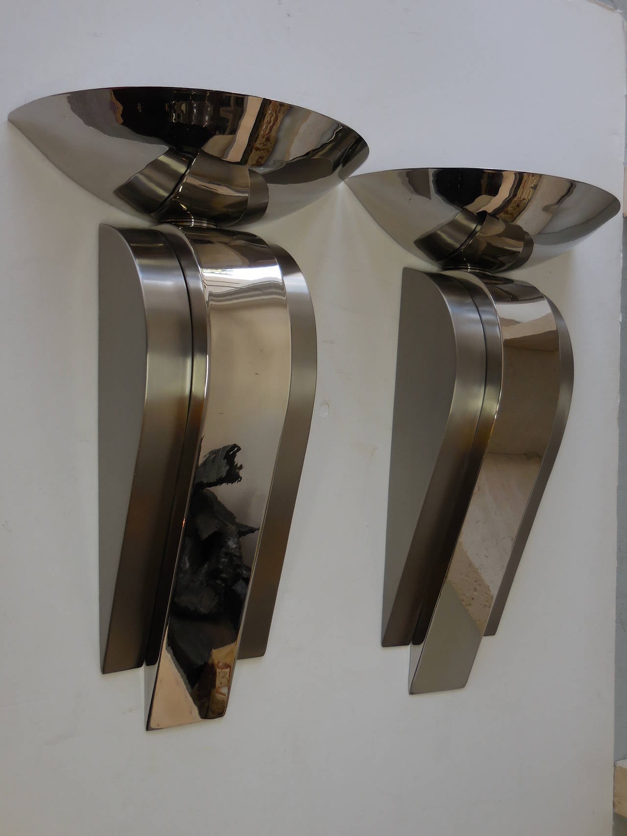 A pair of large stainless steel sconces. Highly polished with brushed areas. Flawless execution with nice detail, note the subtle flaring of the disk.