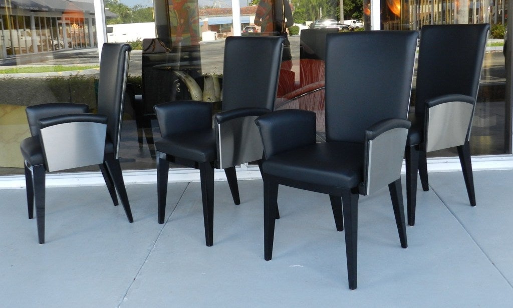 8 high quality Italian arm chairs. Seamless construction. Outside of back and arms is done in brushed stainless steel. Black leather upholstery and lacquer legs. Arms are removable.