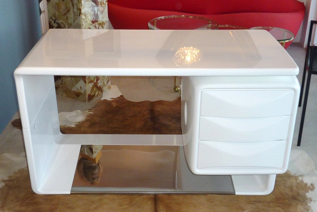 A 1970s desk designed by Wilhelm Igl Design. White gloss lacquer on fiber glass with a stainless footrest. The floating chest has 3 drawers.