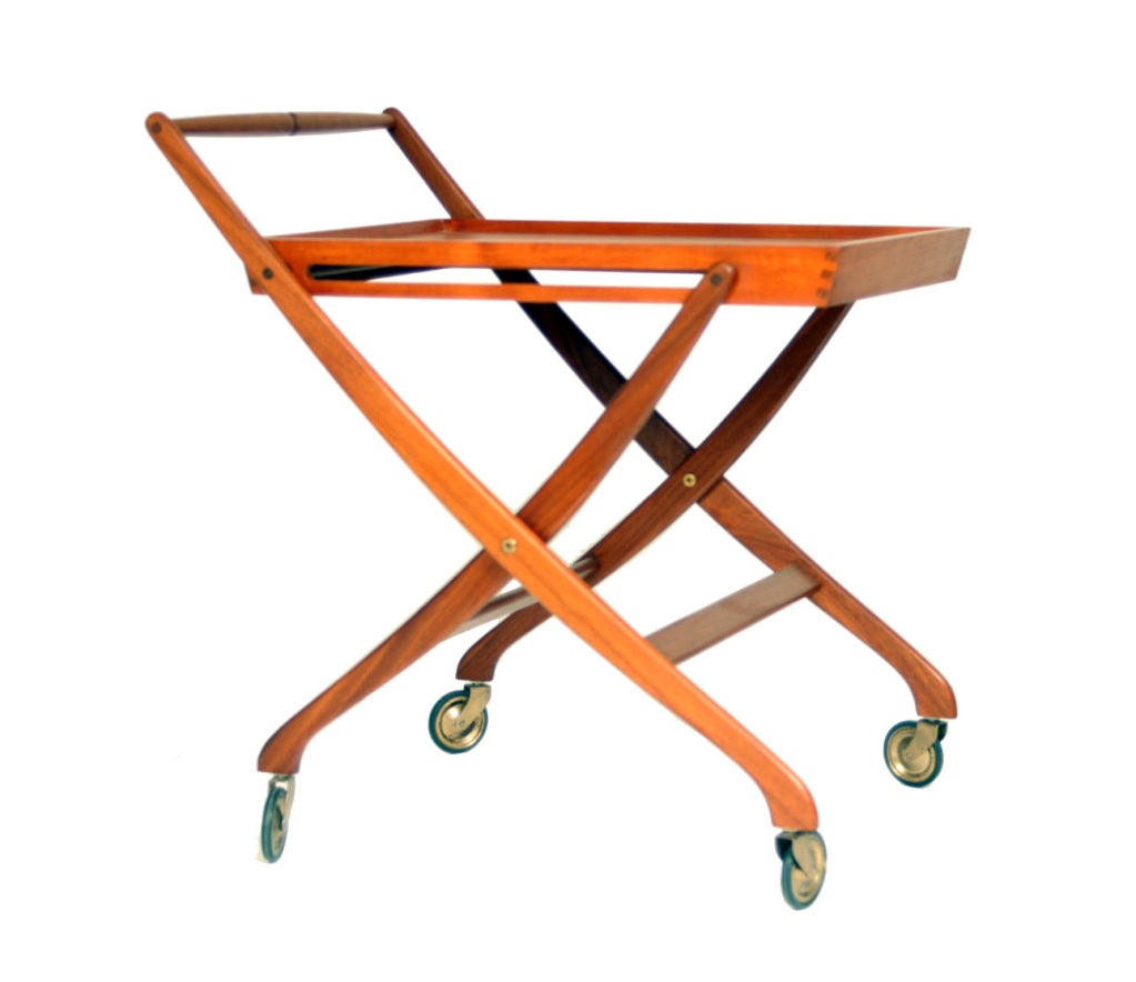 A sleek and elegant teak serving cart with dovetailed corners. The cart folds up conveniently for storage, but who would want to hide such a beautiful piece.  The Danish control label Has been burned into the underside of the cart, dating this item