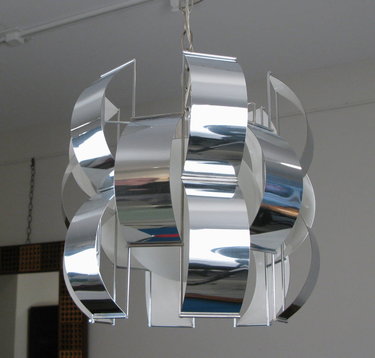 A handsome pendant light from the 70's by Max Sauze. The glass globe and white enamel inside of the chrome fixture gives it a soft glow.