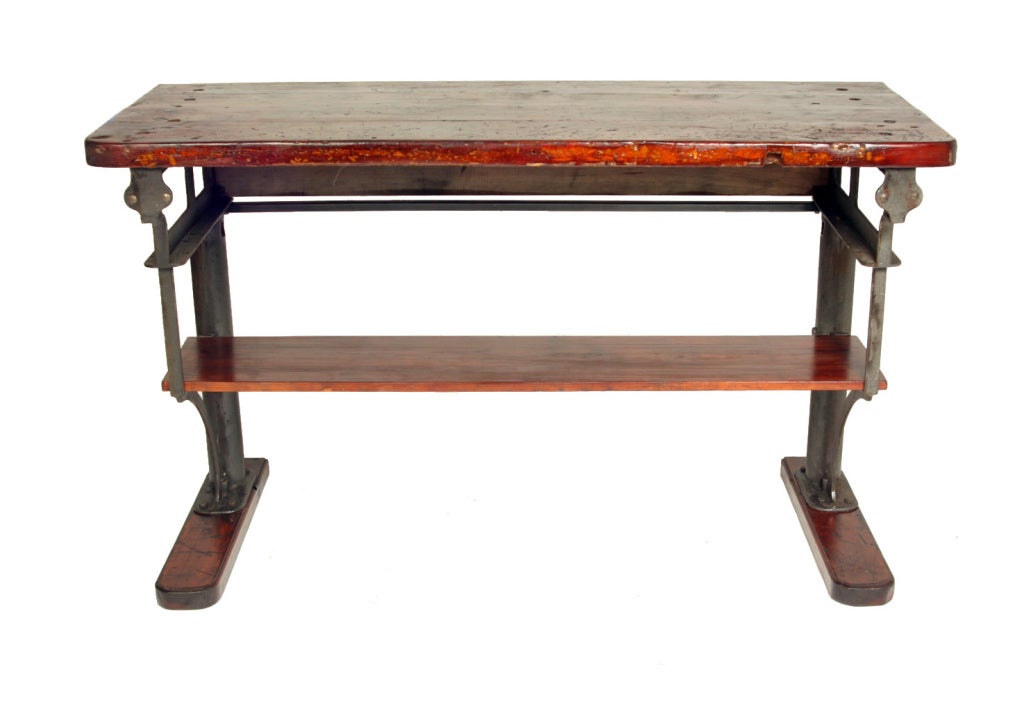 This completely authentic work table / workbench comes straight from a long-shuttered New England textile mill.  The fabulous graphic look of the cast iron stanchions is complimented by the thick wood top, which proudly displays signs of its age and