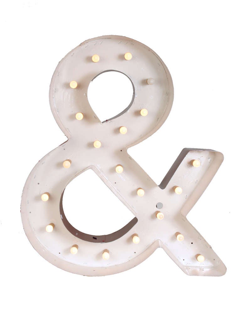 This 30 inch tall sheet metal ampersand symbol was once a part of an outdoor neon sign, but is now ready to come in from the cold and light up your decor.  We've removed the neon tubes and replaced them with low wattage candelabra based bulbs that