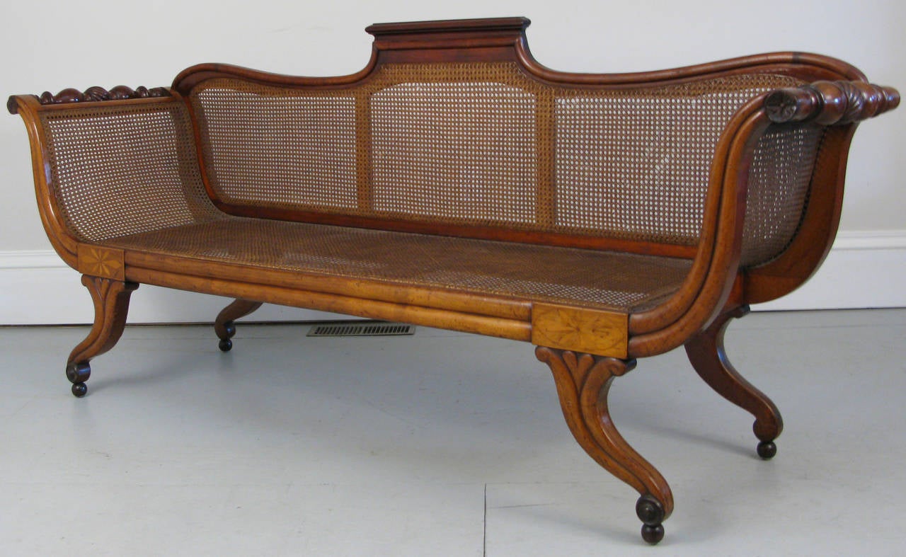 An 1830s-1840s mahogany Anglo-Caribbean caned settee. A truly elegant piece that demonstrates a mix of English Regency design with the Caribbean freedom of interpretation. Everything about this piece is wonderfully exaggerated from the bulbous