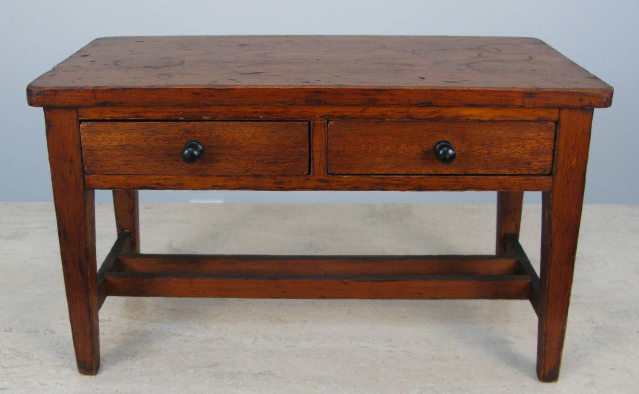 Charming sample size two-drawer work table in what is probably chestnut. Very nice proportions with dovetailed drawers and joined stretchers. The customer would have looked at this small sample before having the to scale piece built. Appears to be