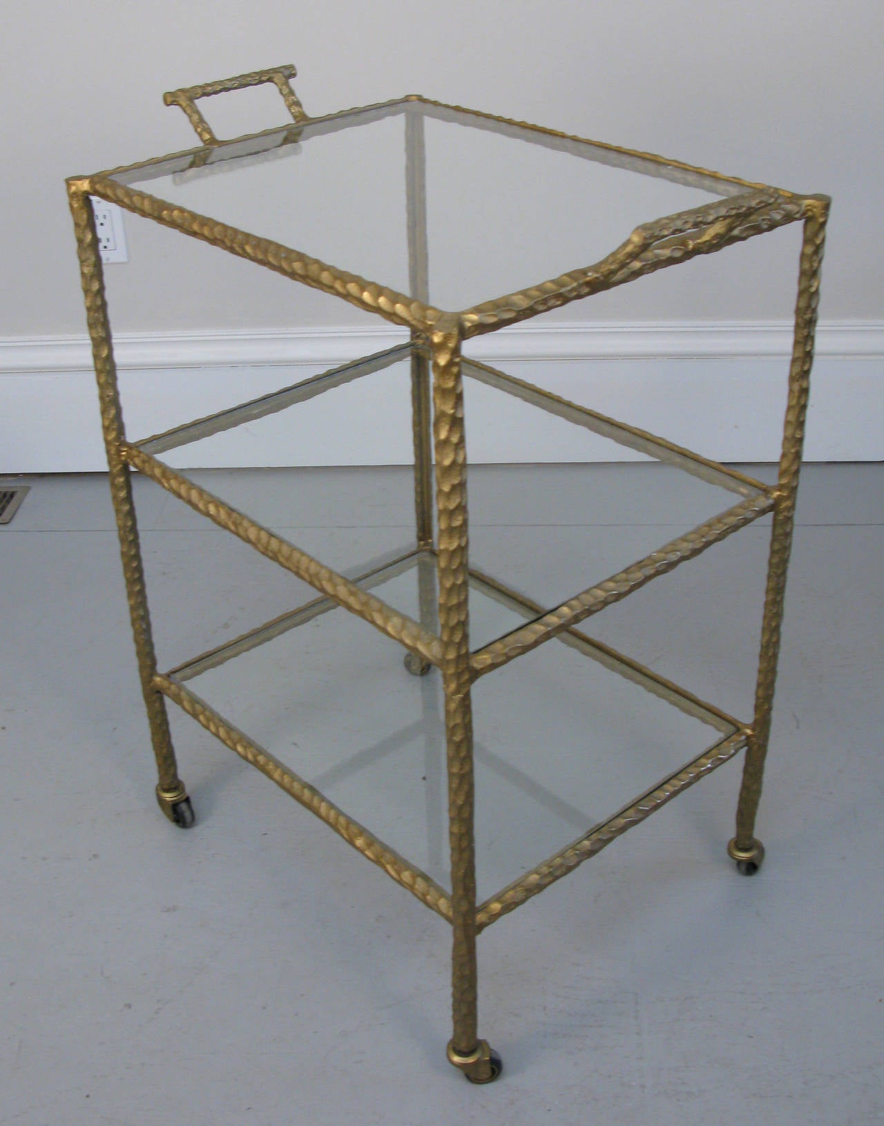 Bold yet delicate looking Mid-Century bar or serving cart made of iron and gold cold painted finish.