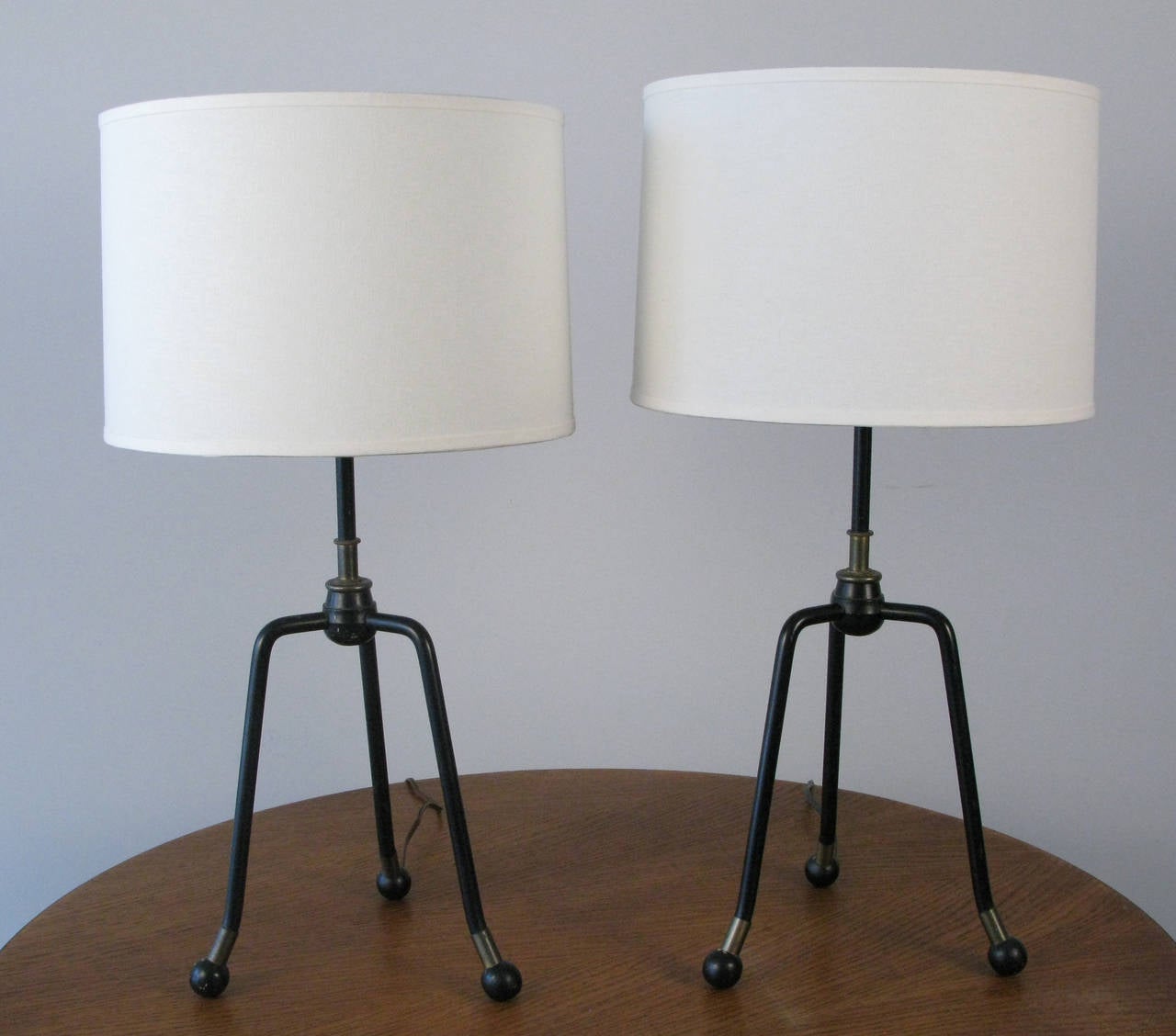 A good looking pair of Iron and brass table lamps. The lamps are both modern and industrial. they end in round wood ball feet.