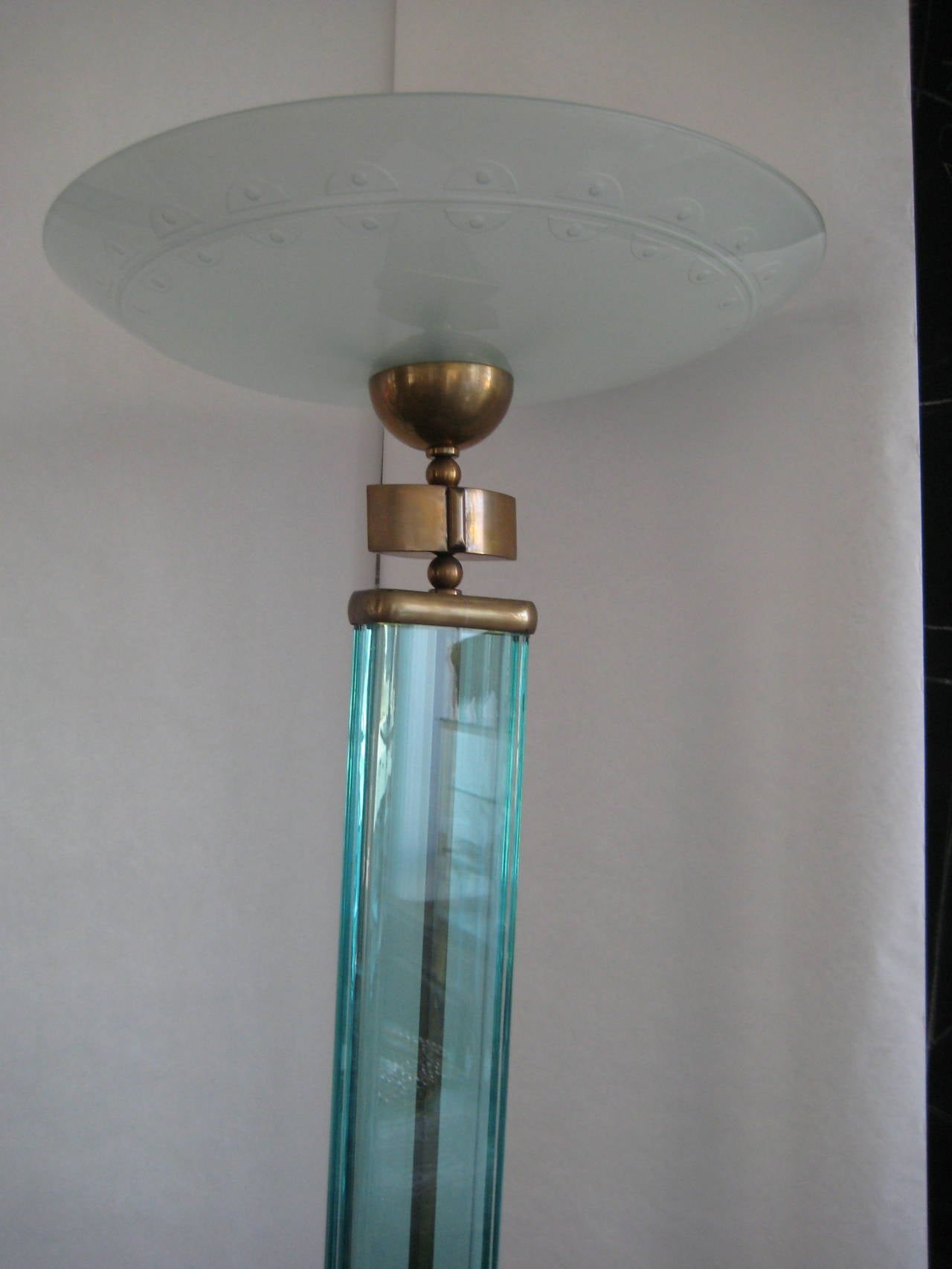 Heavy glass column supporting a large glass shade which
directs light upwards.