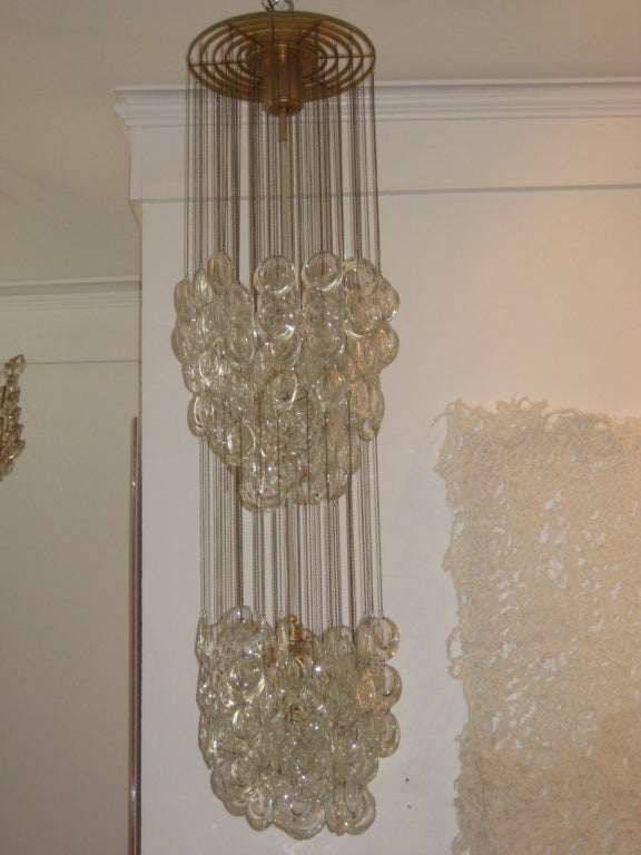 Groups of finely molded and polished disks of glass suspended on chains  from a delicate gilded armature.