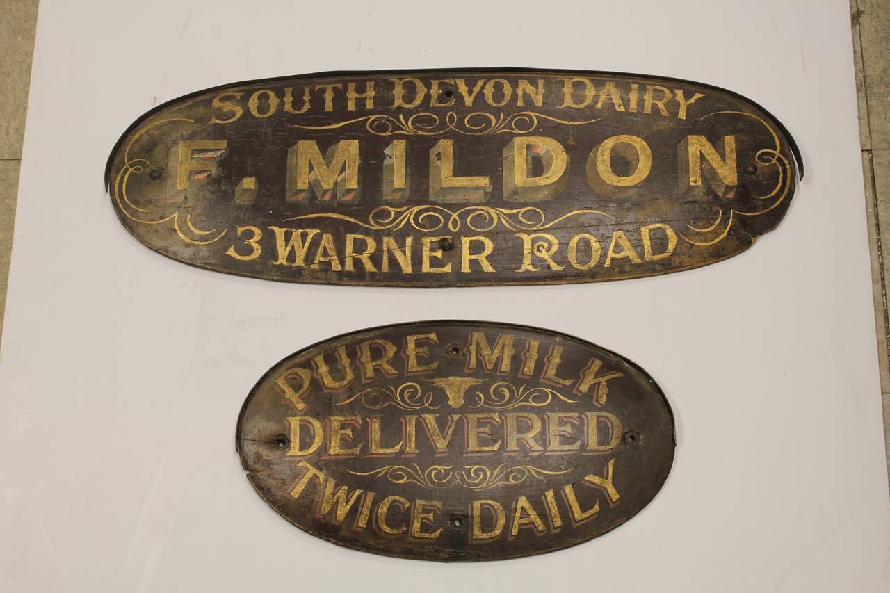 Collection of two antique English hand painted wood dairy signs. Hangers are attached to the back. Large sign: 32.5