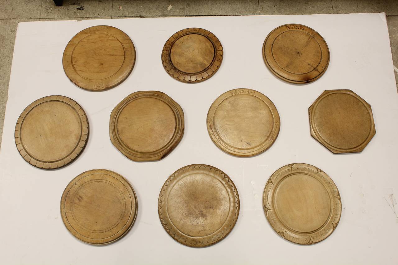 Collection of 10 antique English hand carved wood bread boards. They have attached hangers.