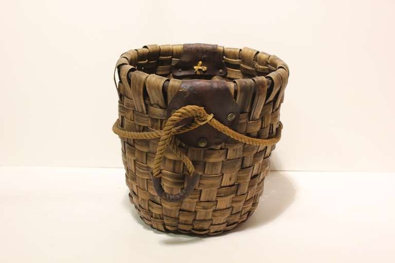 Large hand woven rustic basket with leather and rope handles.