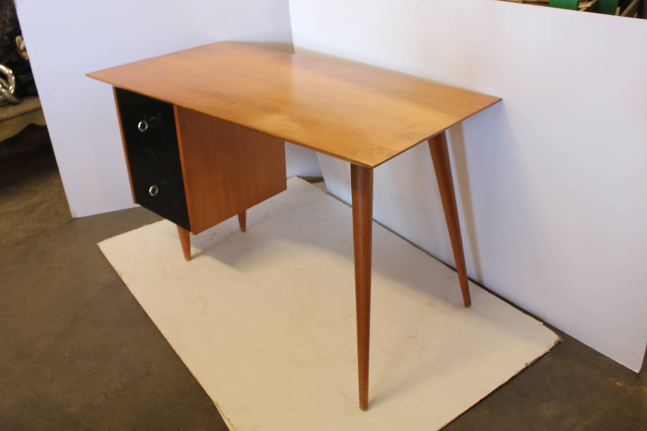 Stylish Paul McCobb Planner Group wood desk with two black lacquered drawers.