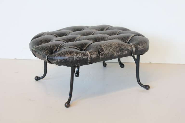 1920's tufted leather and iron base footstool.