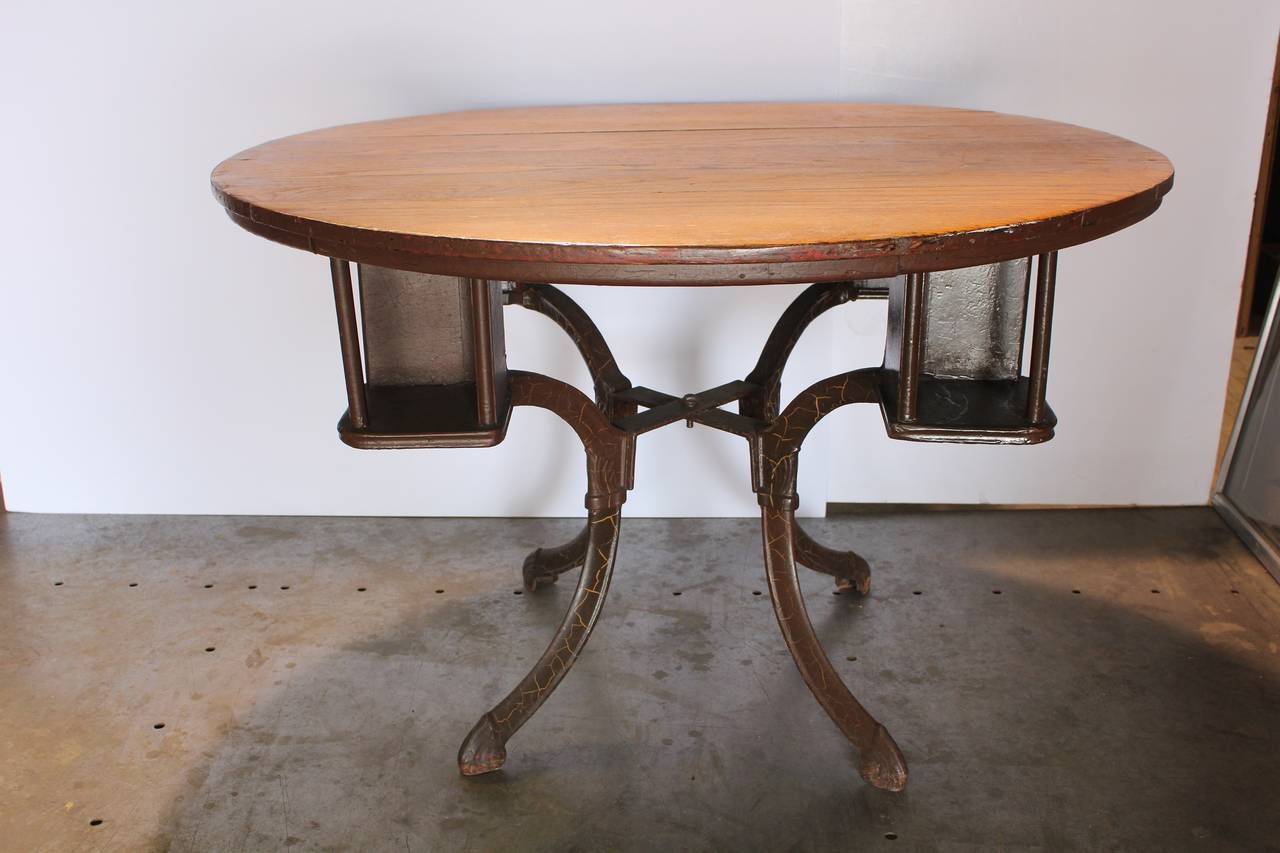 Antique American game table with cast iron base and oak top.