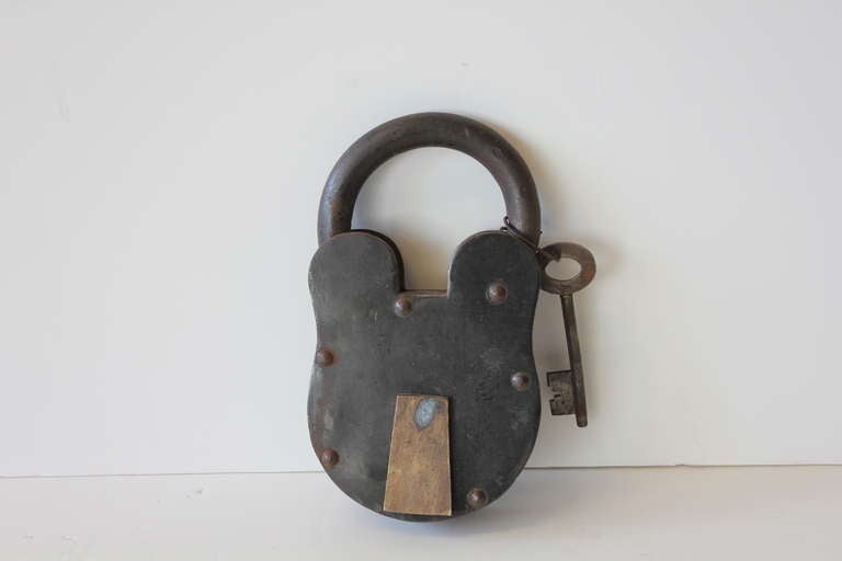Giant antique iron padlock with a skeleton key.