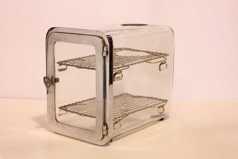 1930's barber shop chrome sterilizer cabinet with wire shelving. On top has a round opening.