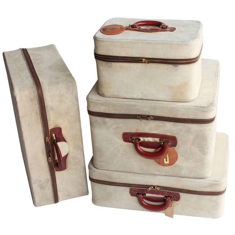 Set of four vintage leather suitcases by Dresner with original canvas covers.