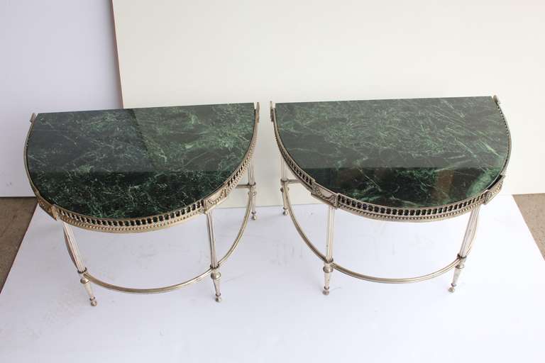 Elegant pair of Jansen style demilune tables with marble tops.
