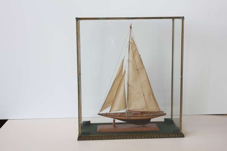Antique wooden model boat in original glass case with wooden base.