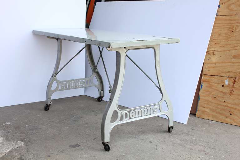Antique industrial table with original porcelain top and cast iron base.