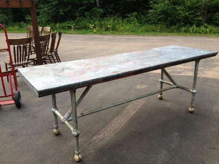 Vintage industrial table with metal base and zinc top.