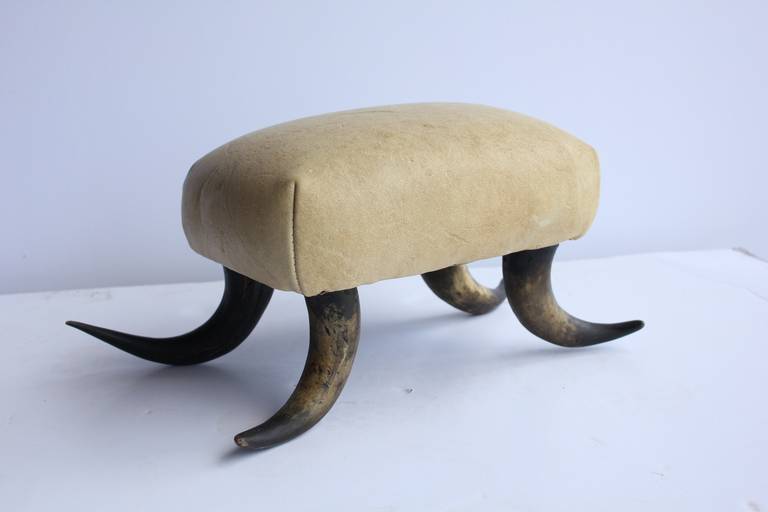 Antique horn based foot stool with leather upholstery.