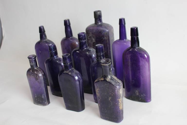 1800's original American Whiskey purple glass bottles. This set includes 11 bottles. More available.