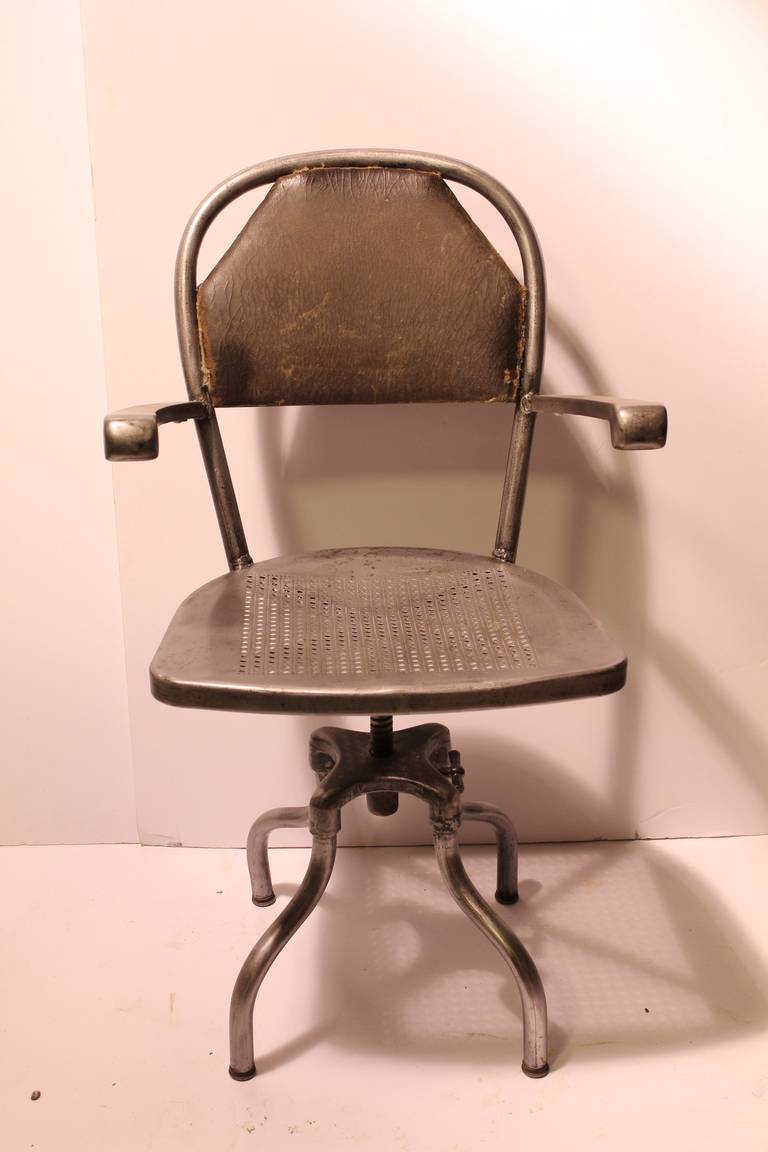 1930's American industrial metal desk chair with a leather back. Adjustable height 17
