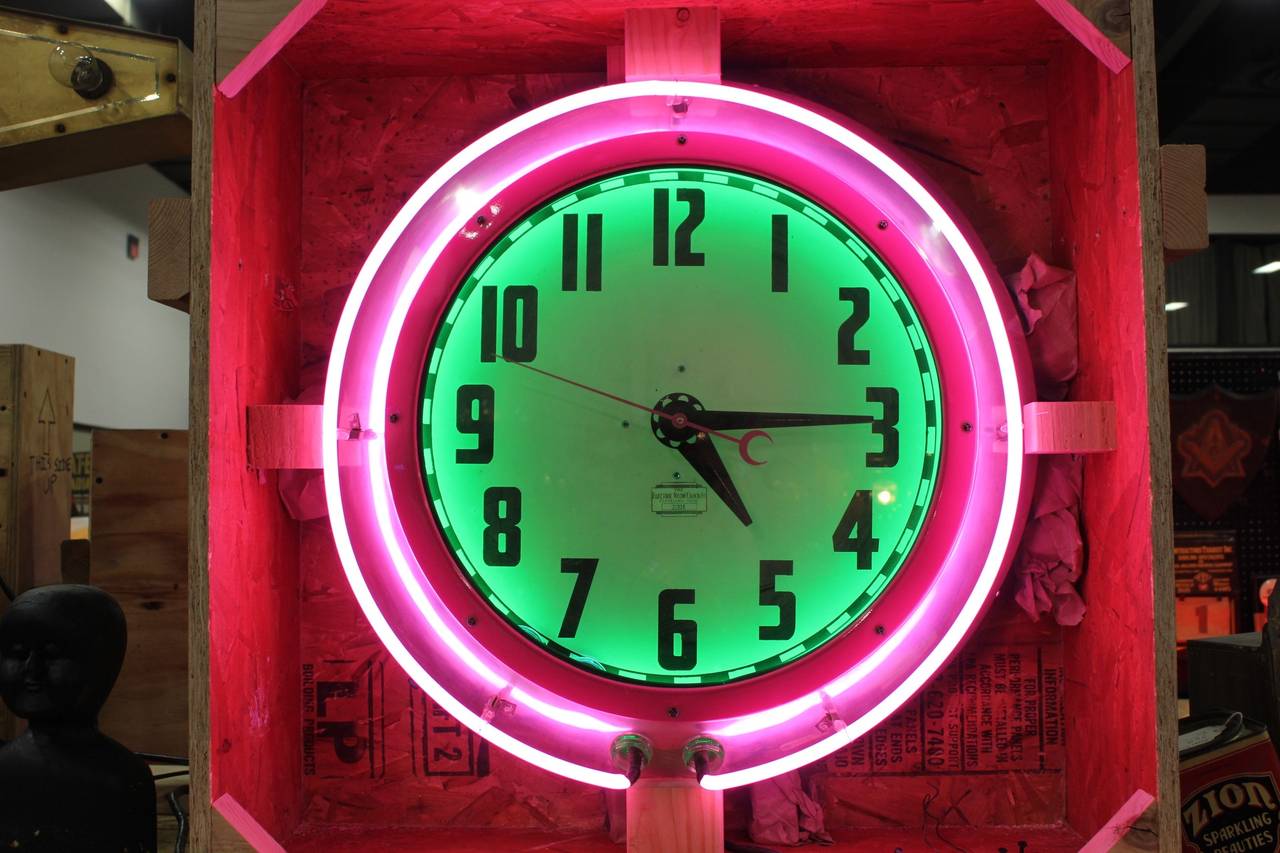 Large 1950s Cleveland, neon clock with pink and green neon.