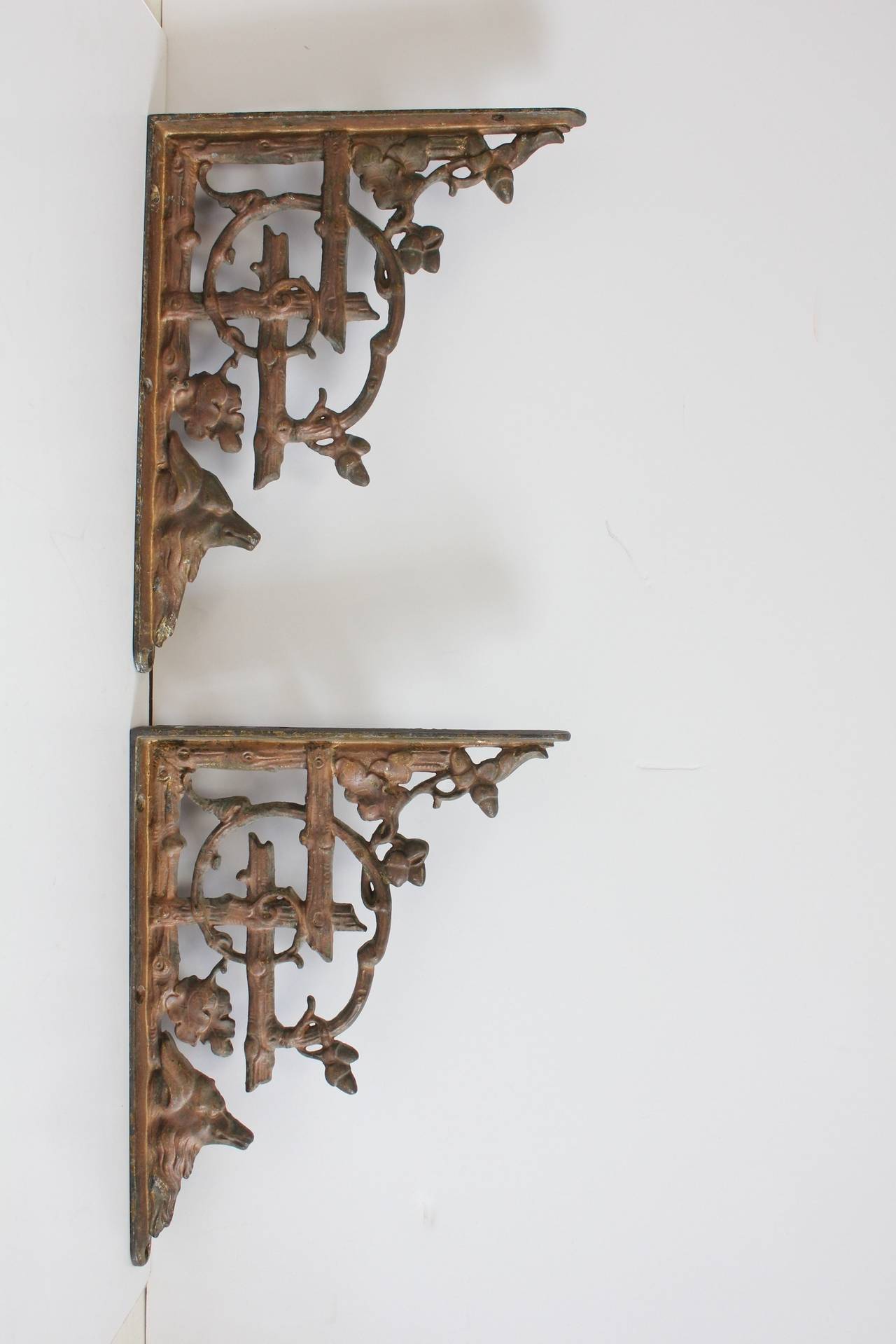 Antique cast iron wall brackets with wolf and acorns design.