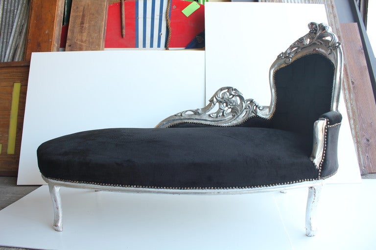 French 19th Century chaise longue with hand carved wooden base and velvet upholstery. The back is tufted.