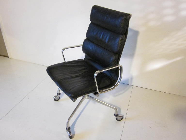 A black leather Eames Aluminum group soft pad executive chair with early rolling base and aluminum arms,Mfg.Herman Miller Company.
