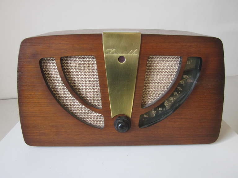 A early and rare designed tube radio by Charles & Ray Eames using post war bent plywood  technology manufactured by the Zenith Radio Corporation,Chicago IL. The radio body is formed with walnut plywood,upholstery speaker screen ,Bakelite knob,brass