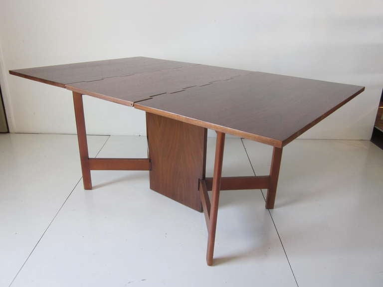A dark walnut topped Nelson gate leg drop leaf dining table with solid wood base, from Herman Millers modular series, Compact and well designed with great detail to the table top hinges and fold out legs.