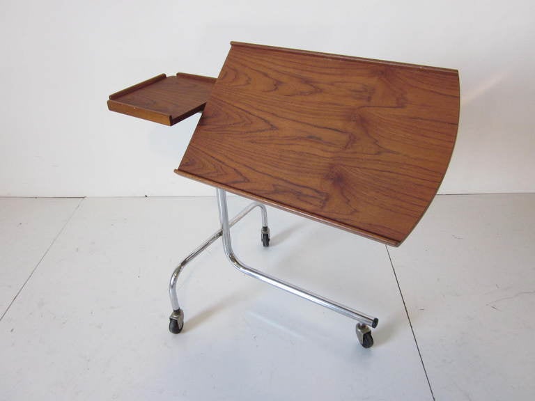A Danish rosewood rolling tray table with chrome base,adjustable table with up and down movement and tilting action,use for computer,I Pad,reading or working at your chair or bed.Adjustable from 24.50